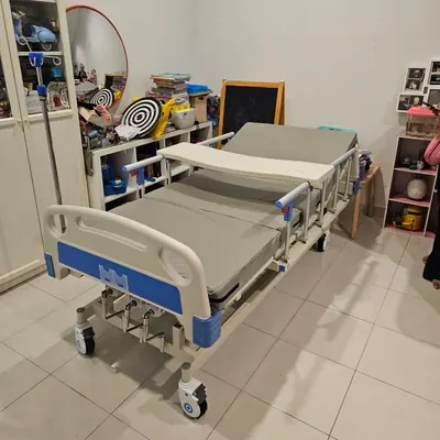 Katil hospital di bilik bersebelahan rak