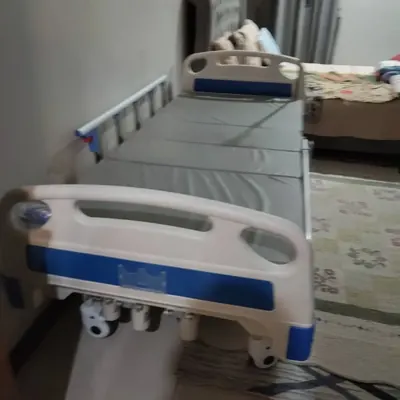 Hospital bed with a grey mattress in a bedroom