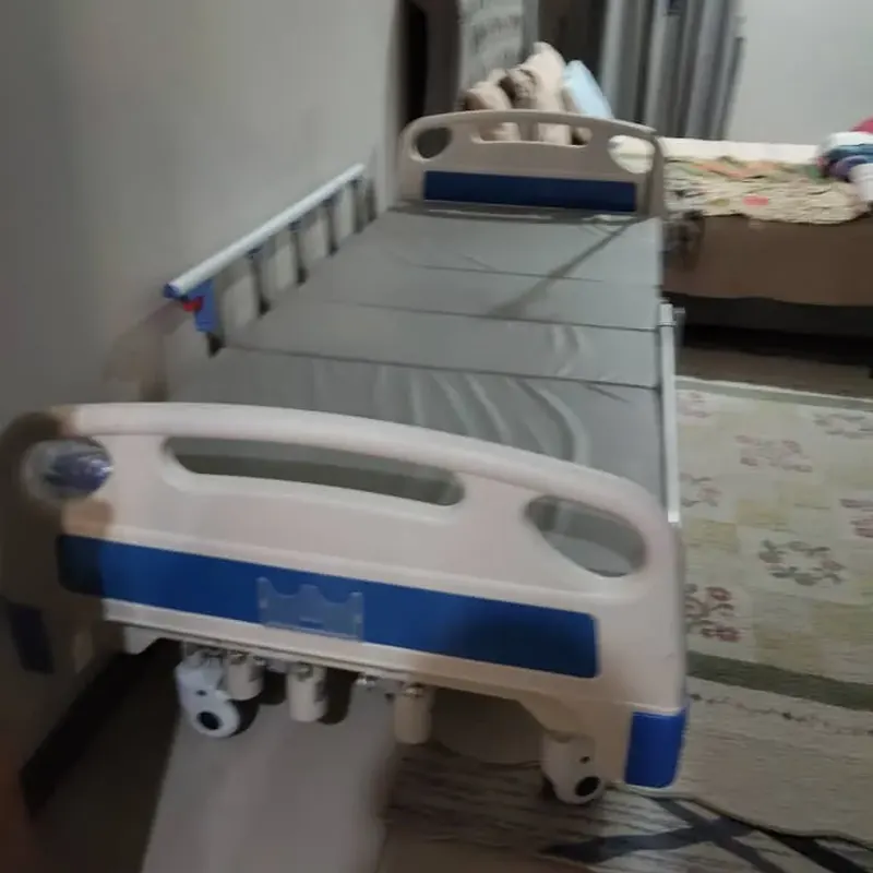 Hospital bed with a grey mattress in a bedroom