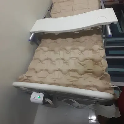 Hospital bed with an air mattress and an overbed table